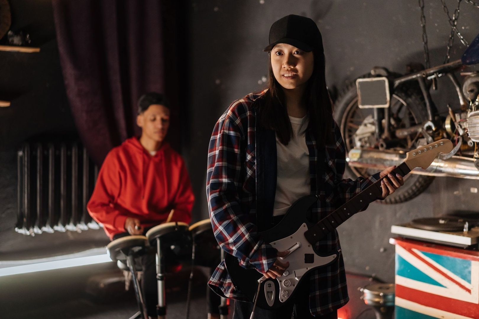 Twee muzikanten repeteren in een garage met gitaar en drums