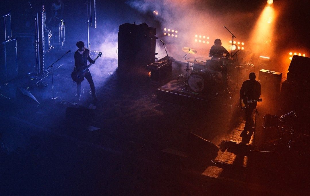 Rockband speelt op een donker podium onder blauwe en oranje belichting