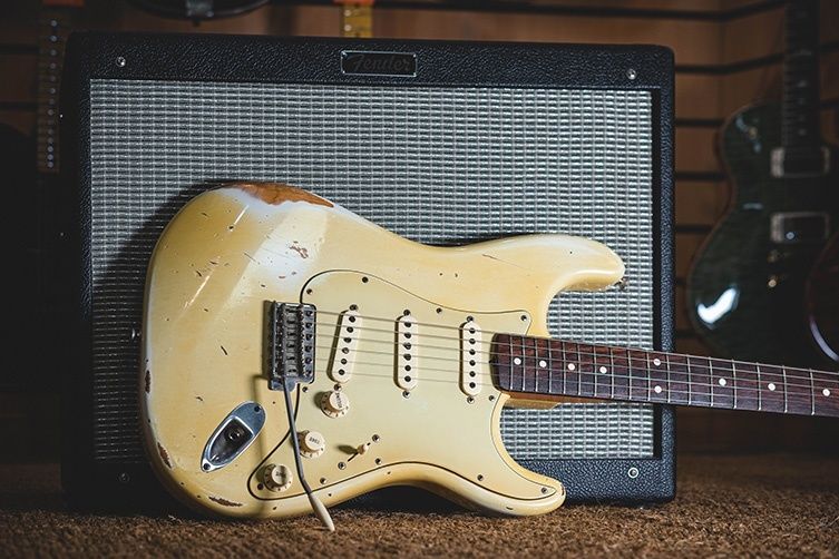 Versleten elektrische gitaar voor een Fender-versterker, passend bij grunge